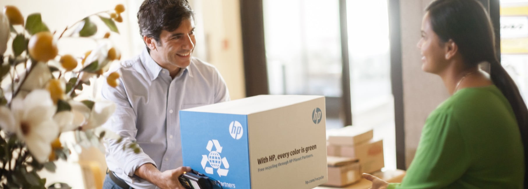 A man handing over an HP package to a woman.