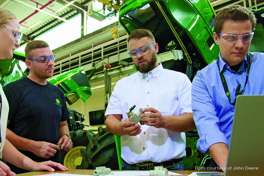 Engineer looking at 3D printed thermal diverting valve by John Deere