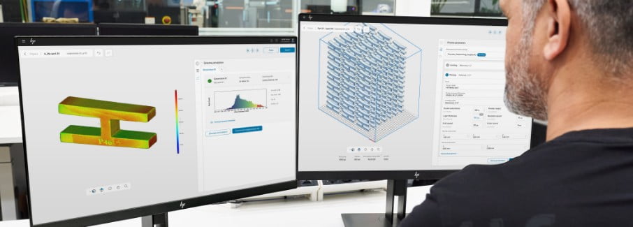 3D printing engineer looking at screen with metal 3D parts