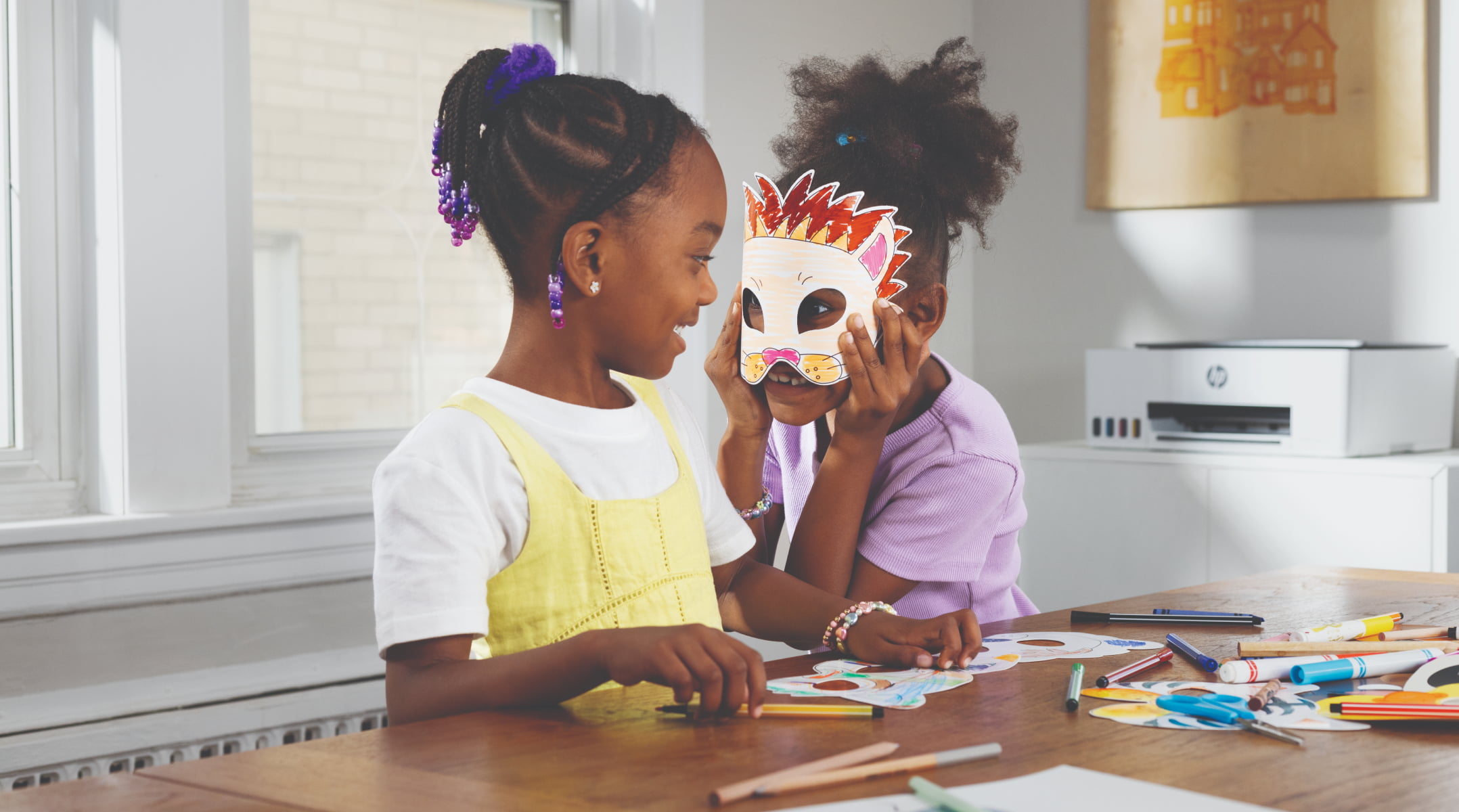 Two girls in masks playing near the HP Smart Tank printer.