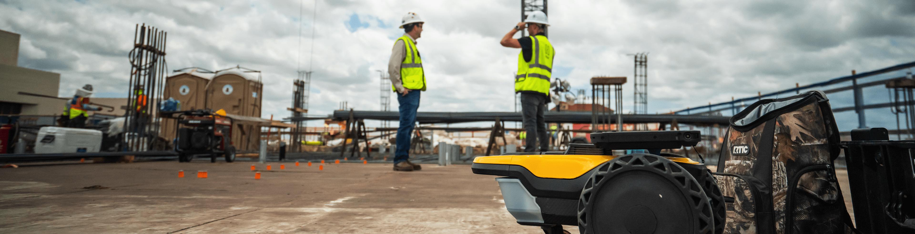 Construction workers on job site with SitePrint robot
