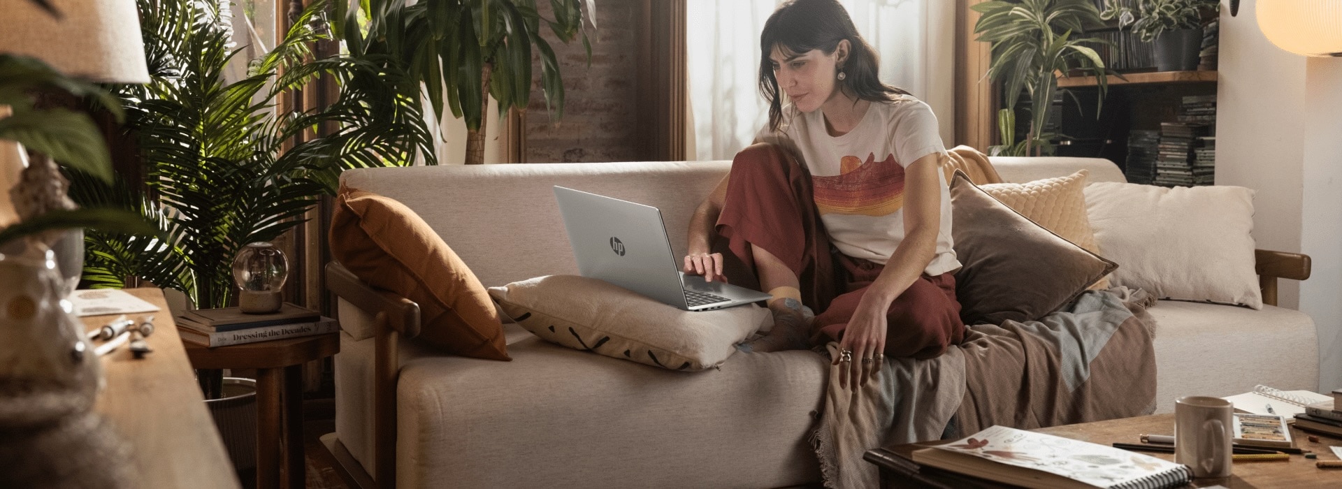 A person lounging on a sofa using their HP OmniBook 5 laptop