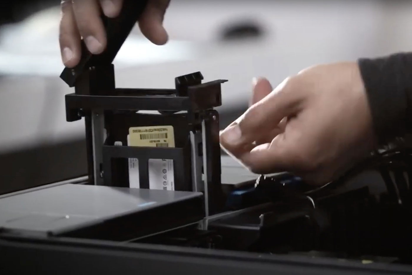 Hands inserting an internal PC component.