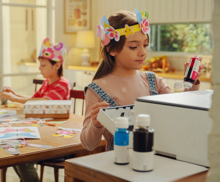 A girl standing next to an HP printer and refilling HP ink.