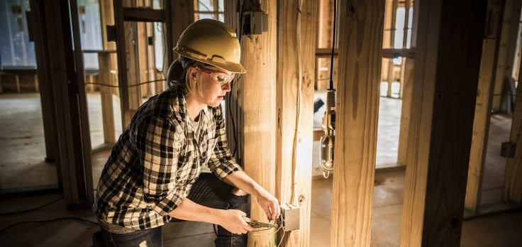 Electrician using different electrical construction tools to wire a residential build