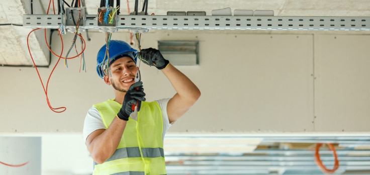 Electrician placing the wiring for new lighting systems for construction installation