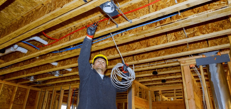 Electrical engineer quickly installing wiring after using an HP SitePrint robot to mark all the locations